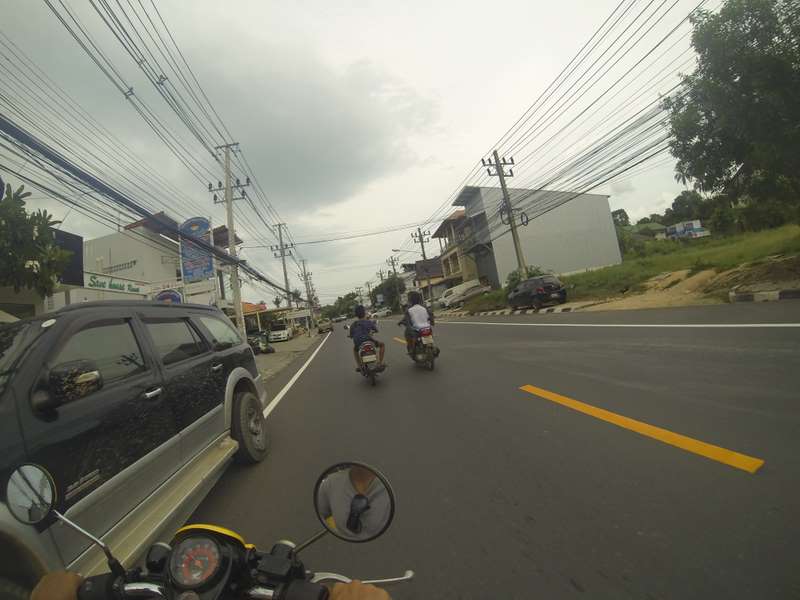 Two children driving and talking. It's very common to see children and whole families riding one scooter