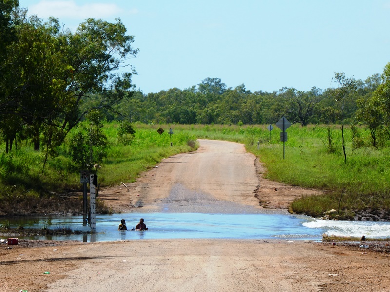 Zdjęcie z rejonu Kimberly, dzieci kąpiące się na zalanej drodze